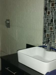 德班Jackies Guest House的浴室设有黑色柜台上的白色水槽