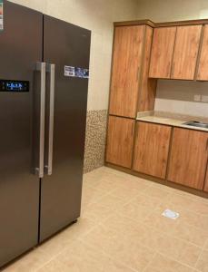 利雅德شقة فاخرة في حطين的厨房配有不锈钢冰箱和木制橱柜