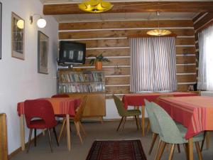 派克波特斯耐兹库Pecka Penzion的一间带桌椅和电视的用餐室