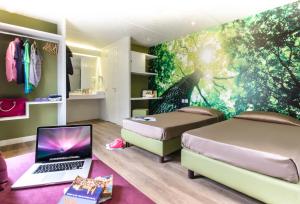 罗马hu Roma Camping In Town的卧室配有两张床和一台笔记本电脑,位于地板上