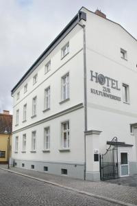 芬特斯沃德Hotel zur Kulturweberei的白色的建筑,上面有酒店标志