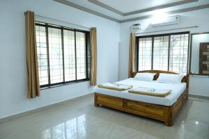 马尔万Hotel Chivla Paradise的一间设有床铺的卧室,位于带窗户的房间内