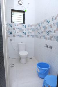 马尔万Hotel Chivla Paradise的一间带卫生间和蓝色桶的浴室