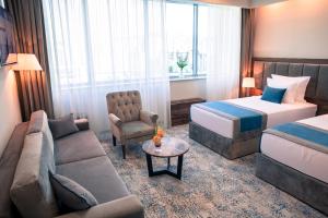 萨拉热窝拉顿广场酒店的酒店客房设有一张沙发和一张床