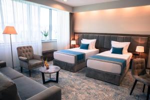 萨拉热窝拉顿广场酒店的酒店客房,设有两张床和一张沙发
