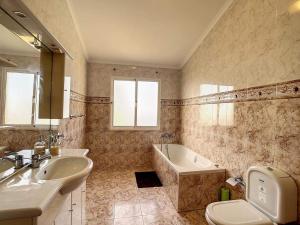滨海保尔Vila Feliz的一间带水槽、浴缸和卫生间的浴室