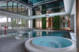 斯维诺乌伊希切Luxury Del Sol Apartments Świnoujście的大楼内带热水浴池的大型游泳池