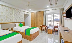 那格浦尔Treebo Trend Chandraprasth Residency的酒店客房配有两张床和一张书桌