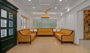 那格浦尔Treebo Trend Chandraprasth Residency的一间设有两把椅子和吊扇的等候室