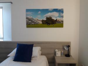 诺里奇Broadview Lodge的一张带蓝色枕头的床和墙上的照片