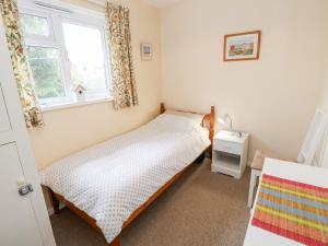 海景城Buddleia Cottage的一间卧室设有两张单人床和一扇窗户。