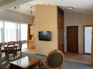 克莱佩达Apartment Senamiesčio Inkaras的客厅配有桌子,墙上配有电视
