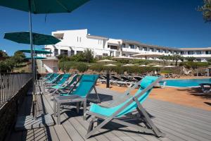 卡达克斯索尔艾克森特酒店的游泳池旁的一排躺椅和遮阳伞