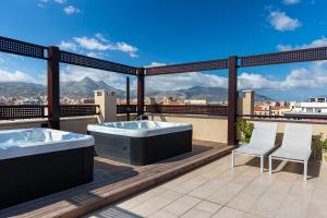 巴勒莫Palermo Blu - Multi Suite的阳台设有热水浴池和2把椅子