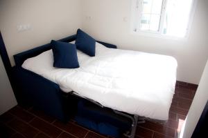 塞维利亚Noches en Triana的一张床上有蓝色枕头的睡床