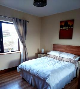 韦斯特波特Ros na gCloch的一间卧室设有一张大床和一个窗户。