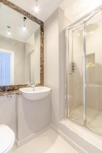 伦敦JOIVY Elegant 2-bed, 2 bath flat with private terrace in South Kensington, close to tube的白色的浴室设有水槽和淋浴。