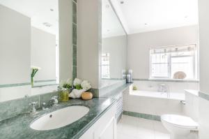 伦敦JOIVY Elegant 2-bed, 2 bath flat with private terrace in South Kensington, close to tube的白色的浴室设有水槽和卫生间。