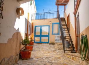 维拉普特祖B&B Ziu Anacletu的房屋内一条带蓝色门和楼梯的小巷