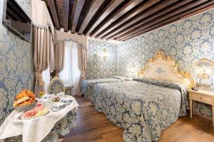威尼斯拉洛贾住宅酒店的一间卧室配有两张床和一张桌子,上面有食物