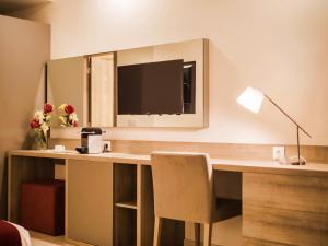 努瓦克肖特蒙诺特尔达尔巴尔卡酒店的一张桌子,电视机和椅子放在房间里