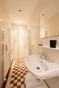 恩克赫伊曾赫伯格宾馆的白色的浴室设有水槽和淋浴。