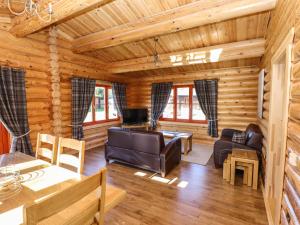 奥克姆Pine Lodge的小木屋客厅配有家具和桌子
