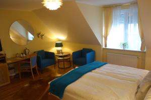 森登范纳穆尔餐厅酒店的一间卧室配有床、两把蓝色椅子和一扇窗户