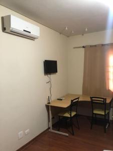 马林加POUSADA Dona Ziza的配有桌椅和电视的客房