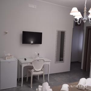 佩斯基奇Residence Arcobaleno的一张带椅子的白色书桌和墙上的电视