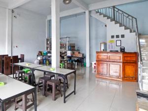 棉兰OYO 90922 Gurusinga Guesthouse的带桌椅的房间和楼梯