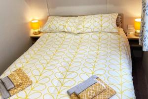 纳尔斯伯勒Lido leisure park的一间卧室配有一张黄色和白色的被子。