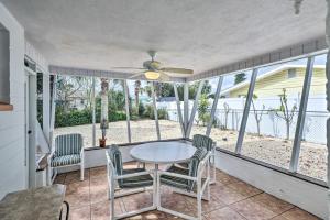 奥蒙德海滩Charming Ormond Beach Home - Walk to Beach!的带桌椅和吊扇的屏蔽门廊