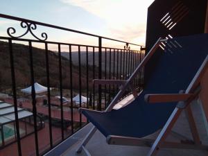 波利齐杰内罗萨Resort San Nicola - Restaurant and Wellness Fitness的美景阳台的蓝色椅子