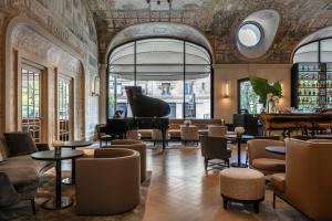 巴黎Hotel Lutetia的大堂设有钢琴和桌椅
