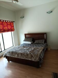 布尔班Bhurban 2bed townhouse with a lawn的一间卧室设有一张床和一个窗口