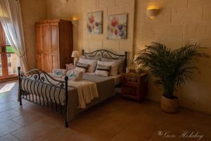 加拉Lellux Qala的一间卧室配有带枕头和植物的床