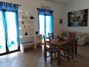 皮诺港Villa panoramica immersa nel verde的客厅配有木桌和椅子