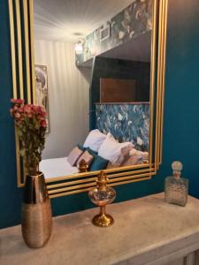 奥弗涅库尔农La Belle Epoque的一间卧室配有一张带镜子的床和花瓶