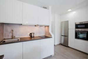 阿德耶El Beril 82, Tenerife的厨房配有白色橱柜和不锈钢冰箱