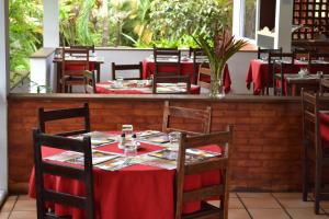 Matoury拉查米耶尔酒店的餐厅配有桌椅和红色桌布