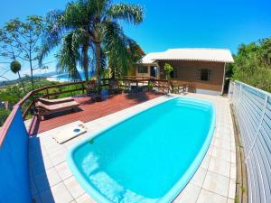 加罗帕巴Casa Vista Privilegiada: Piscina e Conforto的一个带房子的庭院中的游泳池