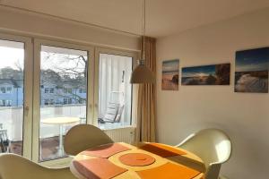 巴贝Villa Stoertebeker Apartment 19的一间带桌椅和窗户的用餐室