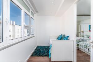 埃斯托利尔Tilias Apartment at Estoril的白色的客房设有床和窗户。