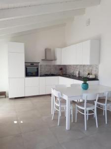 托里格兰德Casa Tonia的白色的厨房配有白色的桌子和椅子