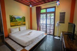 峇都丁宜失乐园度假酒店的一间卧室设有一张床、一台电视和一个窗口。