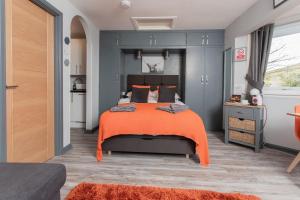 蒂恩格Soay@Knock View Apartments, Sleat, Isle of Skye的一间卧室配有一张带橙色毯子的大床