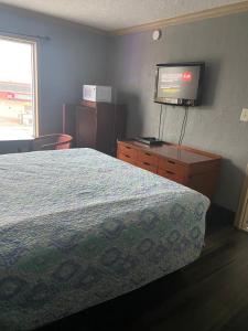加尔维斯敦冲浪汽车旅馆和公寓的一间卧室配有一张床和一台平面电视