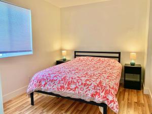 圣布鲁诺Entire 3 bedroom house for 6 people Near SFO SF Bay Area Newly updated的一间卧室配有一张带红色棉被的床和窗户。