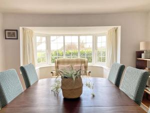 斯利福德Grange Farm Cottage的一间带木桌和椅子的用餐室